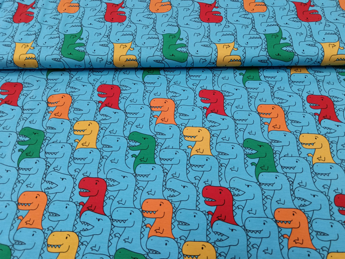 Kinderjersey in blau aus Baumwolle mit bunten Dino Karikaturen - Modemeter Stoffmarkt