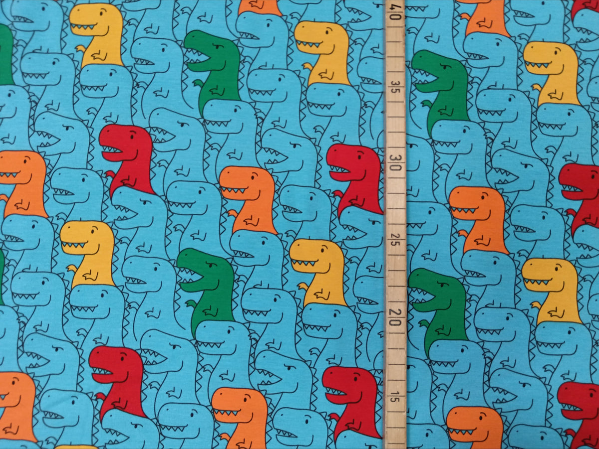 Kinderjersey in blau aus Baumwolle mit bunten Dino Karikaturen - Modemeter Stoffmarkt