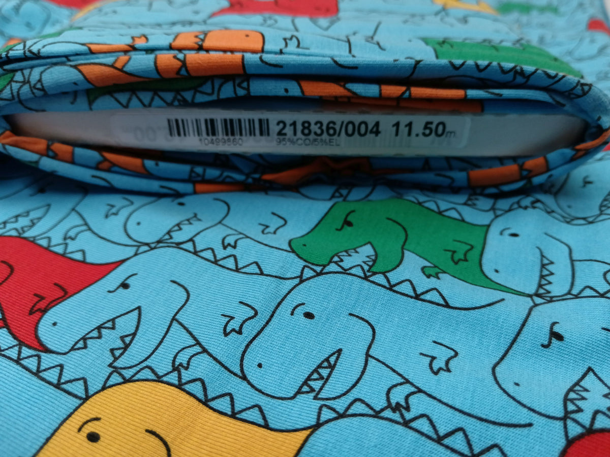 Kinderjersey in blau aus Baumwolle mit bunten Dino Karikaturen - Modemeter Stoffmarkt